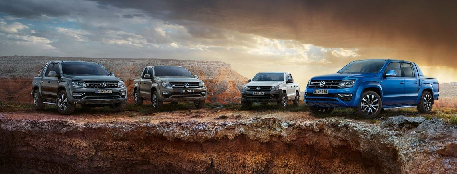 Four first-generation Volkswagen Amarok dual cabs on an escarpment